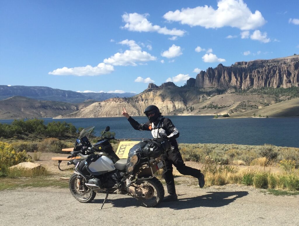 Man on a BMW R1200GSA adventure motorcycle in front of a lake
